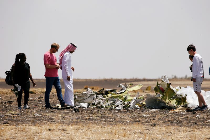 Family and friends of victims of the Ethiopian Airlines Flight ET 302 plane crash, look at debris after a commemoration ceremony at the scene of the crash, near the town of Bishoftu, southeast of Addis Ababa