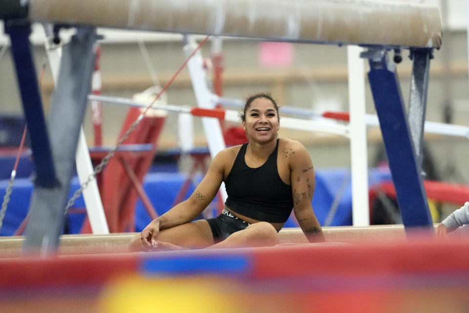 Gymnast Jordan Chiles smiles as she takes a break during a training session Thursday, Feb. 29, 2024, in Spring, Texas. Chiles doesn't have to put herself through this. She knows this. The proof is tattooed on her arm. It's sitting in her trophy room. It's on her social media pages, which are dotted with the kind of partnerships she once never dreamed possible.(AP Photo/David J. Phillip)