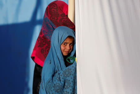 An internally displaced Afghan girl stands outside her tent at a refugee camp in Herat province, Afghanistan October 14, 2018. Picture taken October 14, 2018. REUTERS/Mohammad Ismail