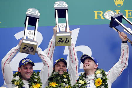 (L-R) Porsche 919 Hybrid number 19 driver Nick Tandy of Britain, Earl Bamber of New Zeland, and Nico Hulkenberg of Germany celebrate on the podium after winning the Le Mans 24-hour sportscar race in Le Mans, central France June 14, 2015. REUTERS/Stephane Mahe
