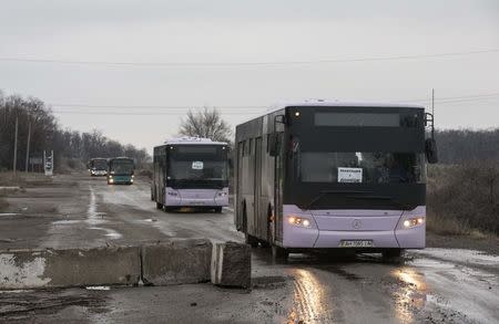 Empty buses, intended for internally displaced persons (IDPs) from the village of Debaltseve, drive in the direction of the village to evacuate the residents, outside Yenakieve town, eastern Ukraine February 6, 2015. REUTERS/Maxim Shemetov