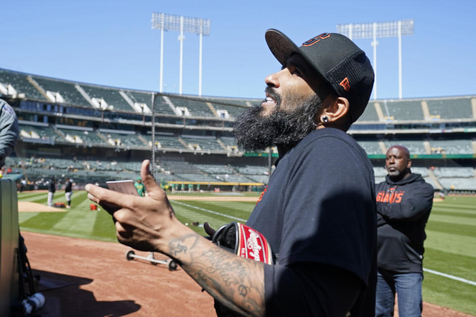 San Francisco Giants pitcher Sergio Romo visits with fans before the start of a spring training baseball game against the Oakland Athletics in Oakland, Calif., Sunday, March 26, 2023. The Giants plan to have Romo pitch on Monday at Oracle Park to mark his retirement. (AP Photo/Eric Risberg)