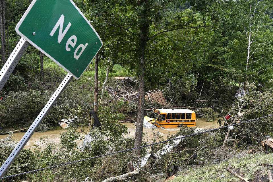 A Perry County school bus lies destroyed after being caught up in the floodwaters of Lost Cree in Ned, Ky., Friday, July 29, 2022. (AP Photo/Timothy D. Easley)