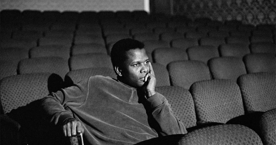 Black and white photo of Sidney Poitier in an empty movie theater