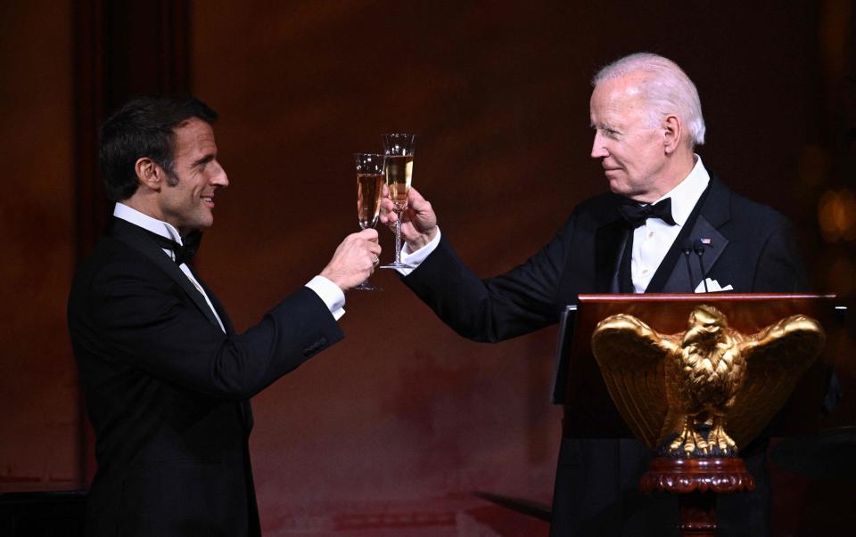 French President Emmanuel Macron and President Joe Biden toast during a state dinner on the  White House South Lawn.