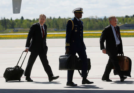 FILE PHOTO: A U.S. military aide, carrying the "football" containing the launch codes for U.S. nuclear weapons, walks from Air Force One between U.S. Trade Representative Robert Lighthizer (L) and National Security Adviser John Bolton (R) as they arrive with U.S. President Donald Trump to attend the nearby G7 Summit in Charlevoix after landing aboard Air Force One at Canadian Forces Base Bagotville in La Baie, Quebec, Canada, June 8, 2018. REUTERS/Leah Millis/File Photo