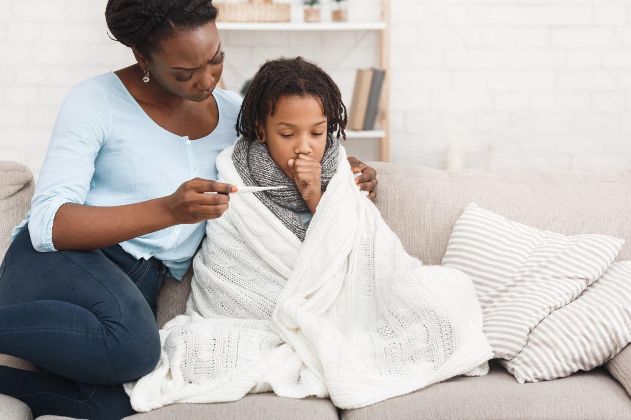 A caring mom checking her sick child's temperature.