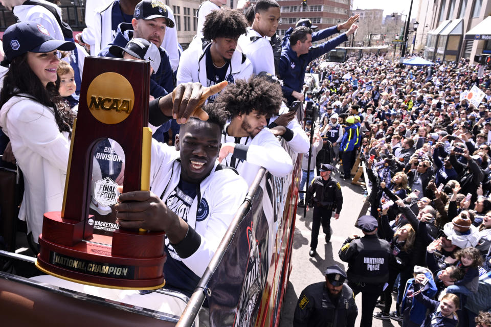 UConn's Adama Sanogo gestures as he holds the trophy during a parade to celebrate the team's NCAA college basketball championship, Saturday, April 8, 2023, in Hartford, Conn. (AP Photo/Jessica Hill)