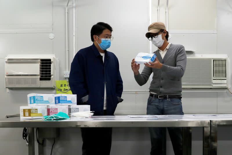 Mask Factory founder Mr. Tang talks to a colleague at his factory, following the outbreak of the new coronavirus, in Hong Kong
