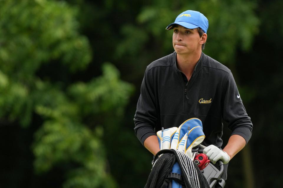 Carmel's Mason Price moves his clubs along the course at hole 18 on the first day of IHSAA boys golf state finals Tuesday, June 13, 2023, at Prairie View Golf Club in Carmel. 