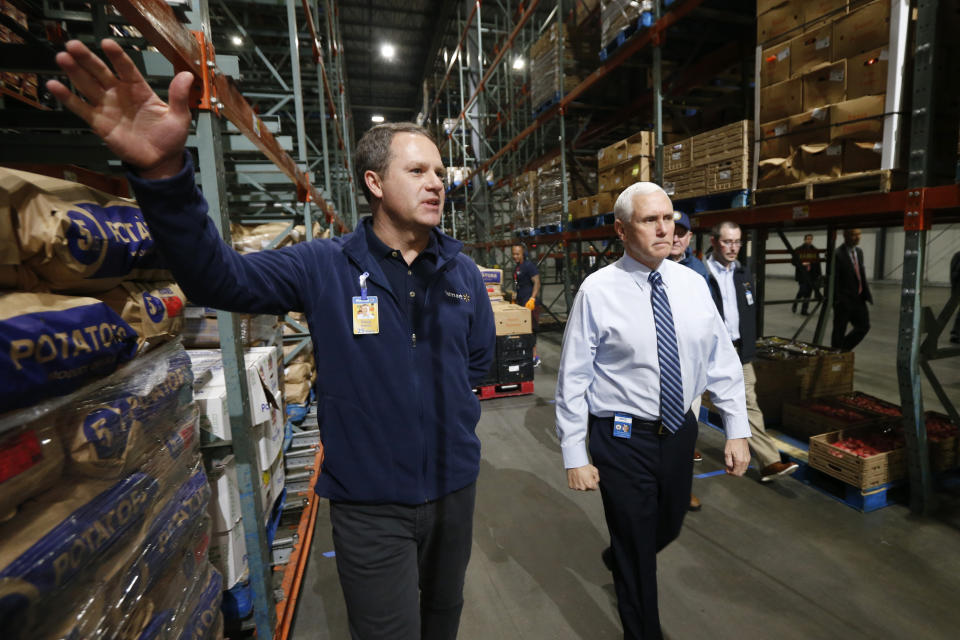 Vice President Mike Pence, right, walks with Walmart president and CEO Doug McMillon, as they tour a Walmart Distribution Center Wednesday, April 1, 2020, in Gordonsville, Va. (AP Photo/Steve Helber)