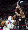 Los Angeles Clippers forward Paul George, left, drives toward Portland Trail Blazers forward Toumani Camara during the second half of an NBA basketball game in Portland, Ore., Wednesday, March 20, 2024. (AP Photo/Craig Mitchelldyer)