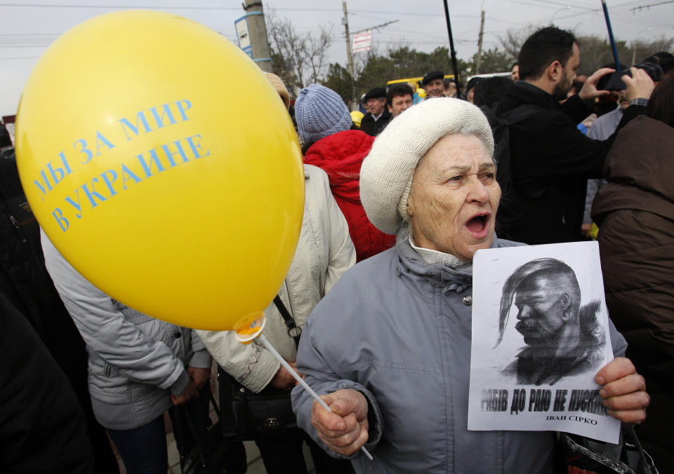 A woman shouts slogans and holds a balloon which reads, "We are for peace in Ukraine" as she attends a rally against the breakup of the country in Simferopol, Crimea, Ukraine, Thursday, March 9, 2014. As separatists in Crimea kept up pressure for unification with Moscow, Ukraine on Sunday solemnly commemorated the 200th anniversary of the birth of its greatest poet, with the prime minister vowing not to give up "a single centimeter" of Ukrainian territory.(AP Photo/Darko Vojinovic)