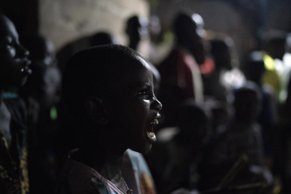 A boy sings during the Kankurang ritual in Bakau, Gambia, Friday, Oct. 1, 2021. The Kankurang rite was recognized in 2005 by UNESCO, which proclaimed it a cultural heritage. Despite his fearsome appearance, the Kankurang symbolizes the spirit that provides order and justice and is considered a protector against evil. He appears at ceremonies where circumcised boys are taught cultural practices, including discipline and respect. (AP Photo/Leo Correa)