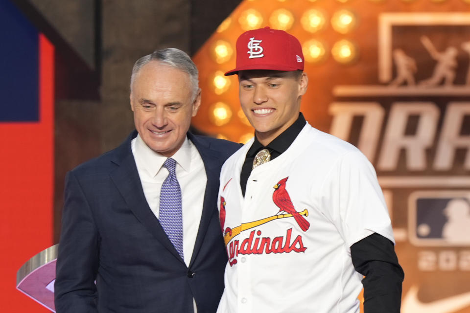 Major League Baseball Commissioner Rob Manfred, left, and JJ Wetherholt, right, pose for a photo after Wetherholt was selected seventh overall by the St. Louis Cardinals in the first round of the MLB baseball draft in Fort Worth, Texas, Sunday, July 14, 2024. (AP Photo/LM Otero)