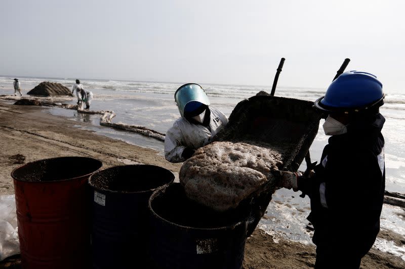 Workers clean up an oil spill in Ventanilla