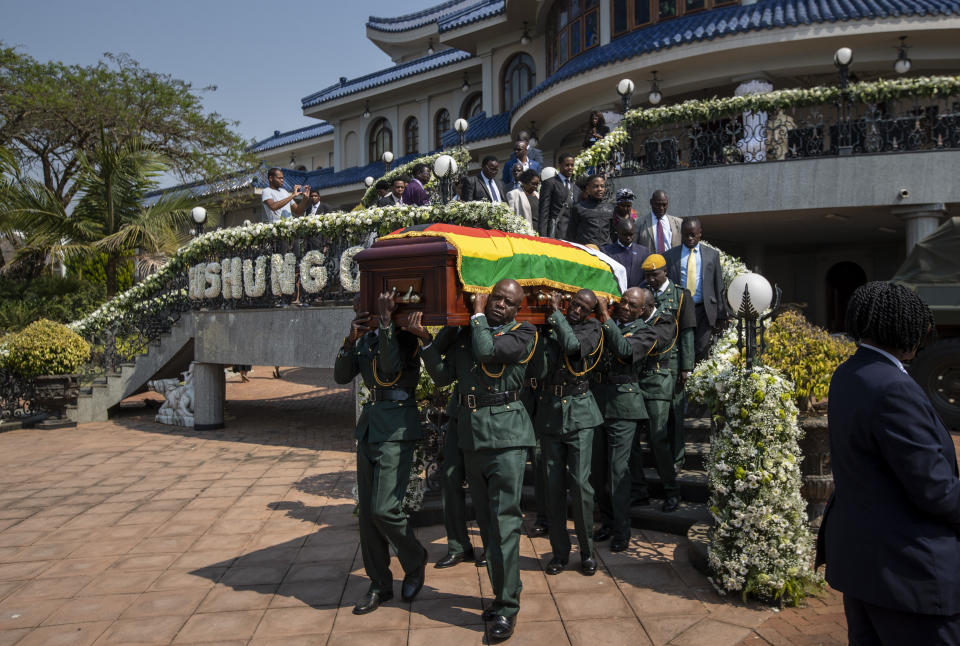 The casket of former president Robert Mugabe is carried by the presidential guard to an air force helicopter for transport to a stadium where it will lie in state, at his official residence in the capital Harare, Zimbabwe Friday, Sept. 13, 2019. The ongoing uncertainty of the burial of Mugabe, who died last week in Singapore at the age of 95, has eclipsed the elaborate plans for Zimbabweans to pay their respects to the former guerrilla leader at several historic sites. (AP Photo/Ben Curtis)