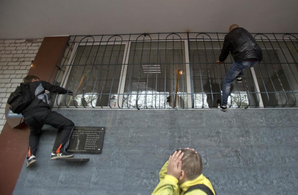 Pro-Russian protesters break windows at a police station building in Odessa, Ukraine, Sunday, May 4, 2014. Several prisoners that were detained during clashes that erupted Friday between pro-Russians and government supporters in the key port on the Black Sea coast were released under the pressure of protesters that broke into a local police station and received a hero's welcome by crowds. (AP Photo/Vadim Ghirda)