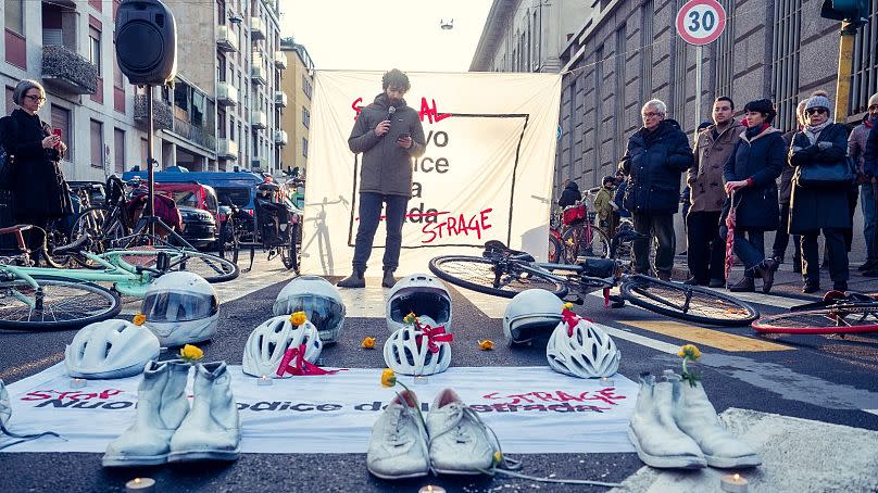 People protest in Milan, in front of a banner that is crossed out to read: "stop the new massacre code".