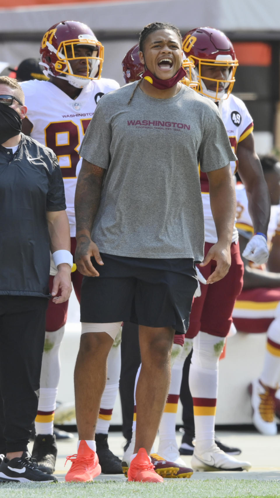 Washington Football Team defensive end Chase Young, right, watches from the sidelines during the second half of an NFL football game against the Cleveland Browns, Sunday, Sept. 27, 2020, in Cleveland. (AP Photo/David Richard)