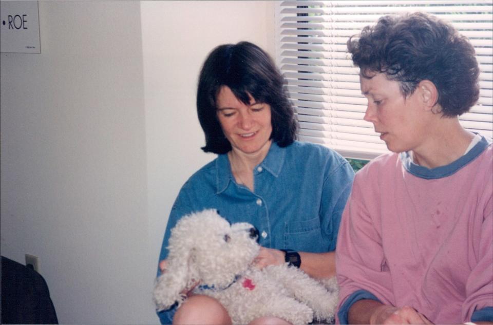 Tam O’Shaughnessy and Sally Ride sharing a tender moment with their bichon pup named Gypsy. <cite>Kay Loveland, Ph.D. courtesy of Tam O’Shaughnessy</cite>