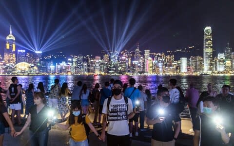 Demonstrators join hands to form a human chain during the Hong Kong Way event in the Tsim Sha Tsui district  - Credit: Bloomberg