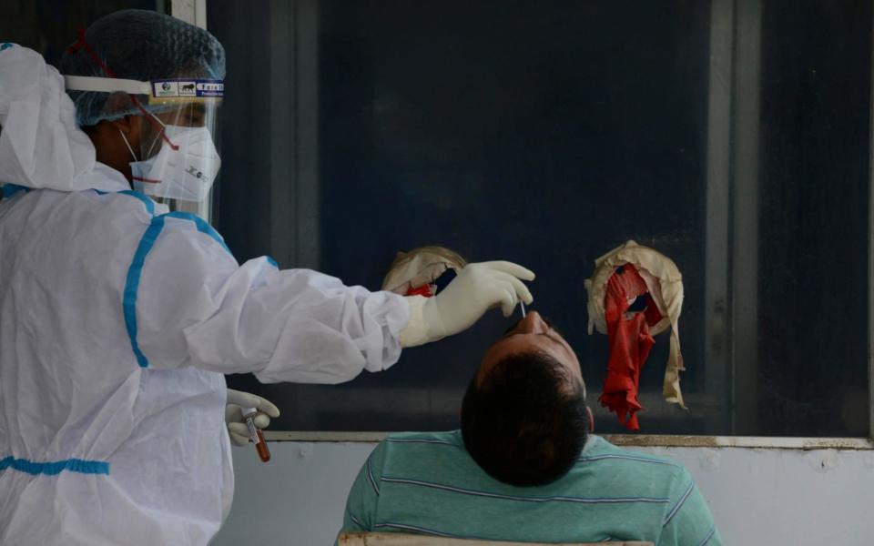 A health worker collects nasal swab for a Covid-19 coronavirus RT PCR test at the North Bengal Medical College and Hospital on the outskirts of Siliguri  - DIPTENDU DUTTA / AFP