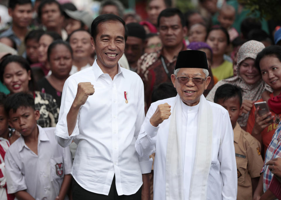 Incumbent Indonesian President Joko Widodo, left, and his running mate Ma'ruf Amin pose for photographers as they declare their victory in the country's presidential election in Jakarta, Indonesia, Monday, Tuesday, May 21, 2019. Widodo has been elected for a second term, official results showed, in a victory over a would-be strongman who aligned himself with Islamic hard-liners and vowed Tuesday to challenge the result in the country's highest court. (AP Photo/Dita Alangkara)