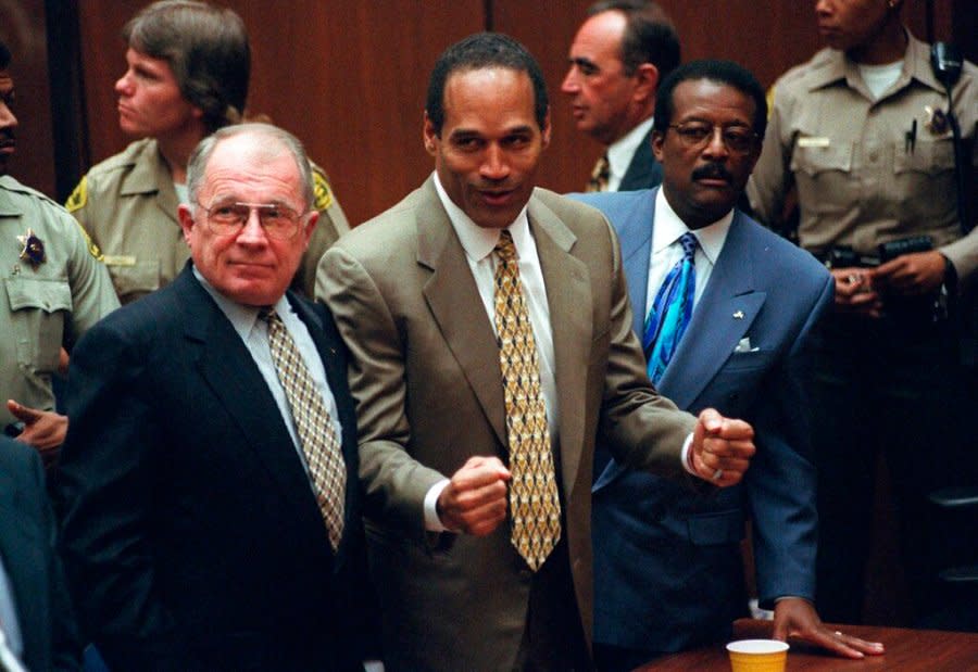 O.J. Simpson, center, with defense attorneys F. Lee Bailey, left, and Johnnie Cochran after Simpson was found not guilty of murdering his ex-wife Nicole Brown Simpson and her friend Ron Goldman at the Criminal Courts Building in Los Angeles on Oct. 3, 1995. (AP Photo/Myung J. Chun, file)