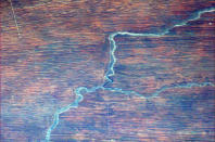 Foto tomada del Twitter de @Cmdr_Hadfield: Un camino, un río, una roca y la arena roja crean una extraña figura en África.