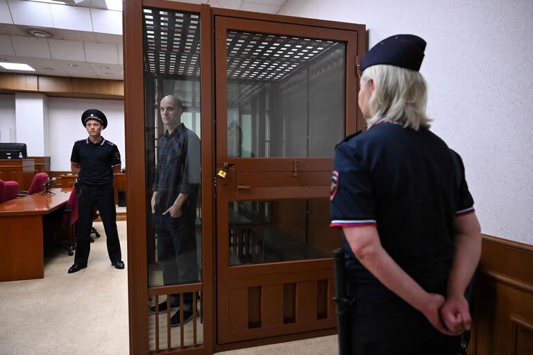 El periodista estadounidense Evan Gershkovich, acusado de espionaje, mira desde el interior de una jaula de acusados de vidrio antes de una audiencia en el Tribunal Regional de Sverdlovsk en Ekaterimburgo, el 26 de junio de 2024.