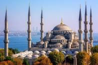 <p>Nicknamed the Blue Mosque for its expansive walls decked out in Iznik tiles, the <a href="http://www.bluemosque.co/" rel="nofollow noopener" target="_blank" data-ylk="slk:Sultan Ahmet Mosque;elm:context_link;itc:0;sec:content-canvas" class="link ">Sultan Ahmet Mosque</a> was commissioned by ruler Ahmet I in 1609. The chosen location of the mosque, facing the Hagia Sophia and hippodrome, caused controversy, as it required many established palaces of Ottoman leaders to be demolished. The structure features five main domes, six minarets, eight secondary domes, and 20,000 tiles inside. It’s important to remember the mosque still holds religious gatherings to this day, so make sure to respect the prayer schedule and dress code as you plan your visit.<br></p>