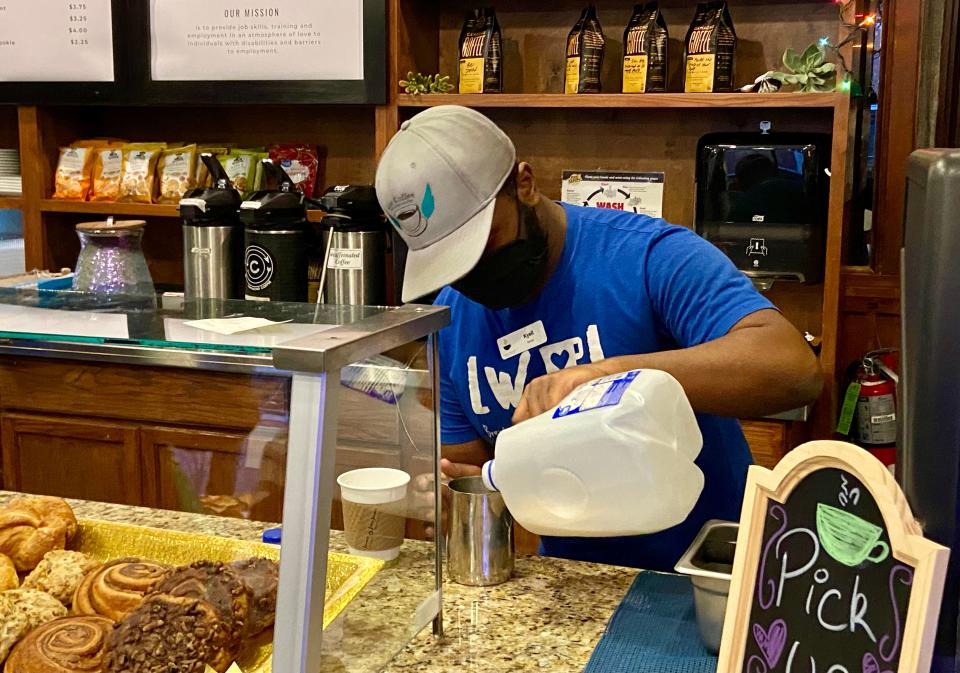 Love Coffee employee Kyell Yisrael pours milk last year at its Tiger Hotel location.