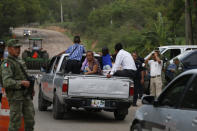 People ride in the back of a pickup as they pass through a temporary immigration checkpoint manned by soldiers wearing armbands for Mexico's National Guard, just north of Ciudad Cuauhtemoc, Chiapas State, Mexico, Saturday, June 15, 2019. Under pressure from the U.S. to slow the flow of migrants north, Mexico plans to deploy thousands of National Guard troops by Tuesday to its southern border region.(AP Photo/Rebecca Blackwell)