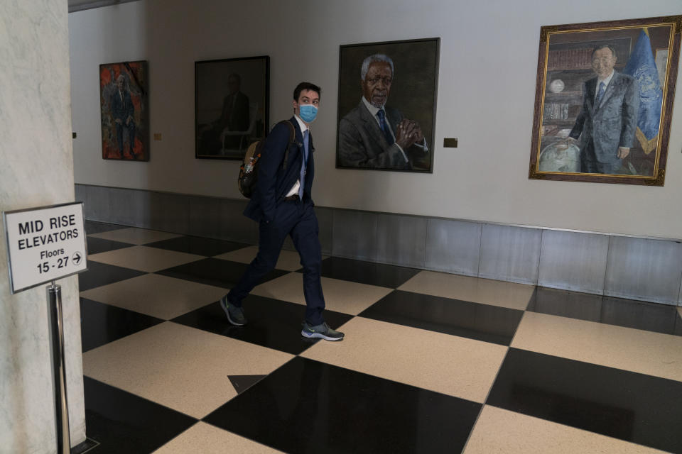 Un hombre camina frente a los retratos de los exsecretarios generales de la ONU, en la 75ta sesión de la Asamblea General de Naciones Unidas, el martes 22 de septiembre de 2020, en la sede de la ONU, en Nueva York. (AP Foto/Mary Altaffer)