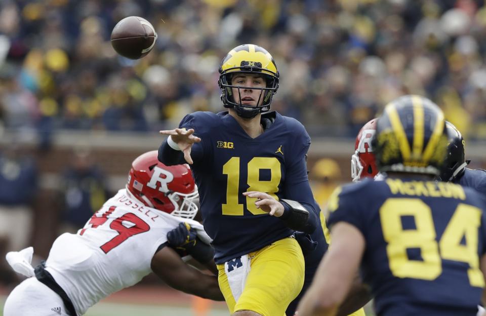 Michigan quarterback Brandon Peters (18) throws while pressured by Rutgers linebacker Brandon Russell (49) during the second half of an NCAA college football game, Saturday, Oct. 28,2017, in Ann Arbor, Mich. (AP Photo/Carlos Osorio)