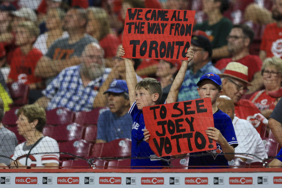 Two young fans hold signs in support of Reds' Joey Votto during the ninth inning of a baseball game between the Miami Marlins and the Cincinnati Reds in Cincinnati, Tuesday, July 26, 2022. The Marlins won 2-1. (AP Photo/Aaron Doster)