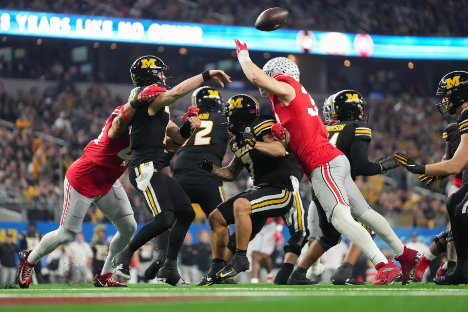 Dec 29, 2023; Arlington, Texas, USA; Ohio State Buckeyes defensive end JT Tuimoloau (44) and defensive end Jack Sawyer (33) hit Missouri Tigers quarterback Brady Cook (12) during the first quarter of the Goodyear Cotton Bowl Classic at AT&T Stadium.