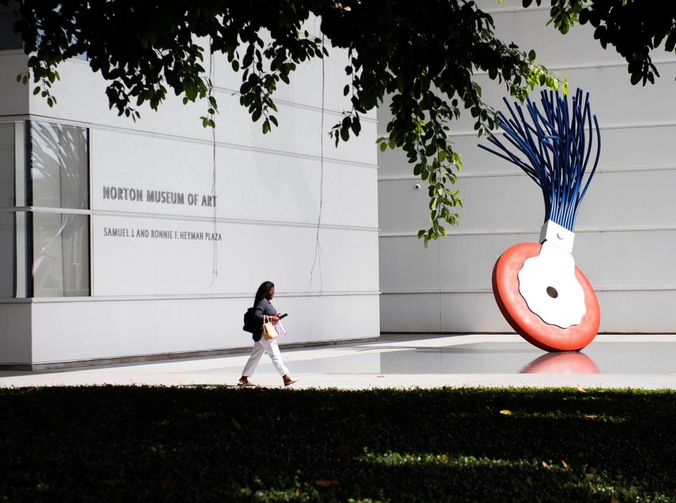 A woman walks by the “Typewriter Eraser, Scale X, 1999” sculpture by Claes Oldenburg in partnership with his late wife, Coosje van Bruggen, at the Norton Museum of Art’s entrance in Palm Beach, Fla. Oldenburg, known as the father of pop art, died July 18 in New York.