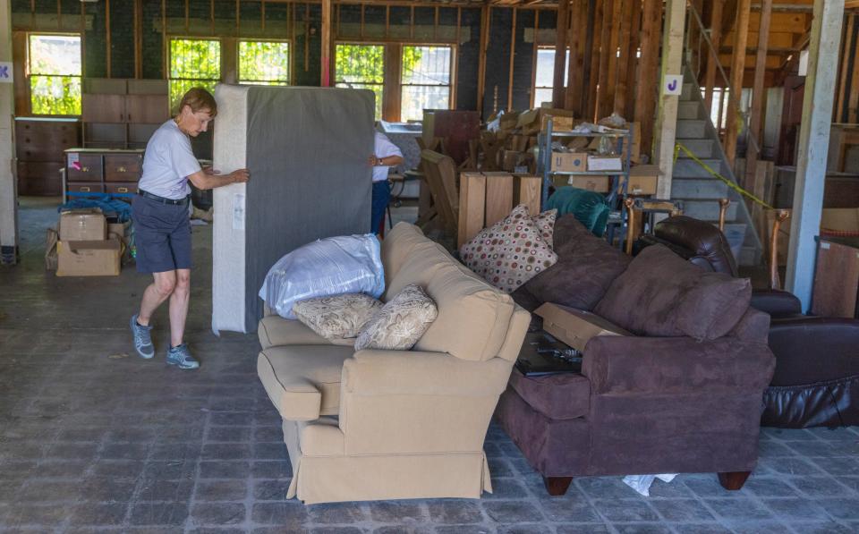 Cynthia Mussinan and other volunteers from Holy Trinity Lutheran Church in Manasquan help load three pickup trucks with furniture and bedding for families in need.
