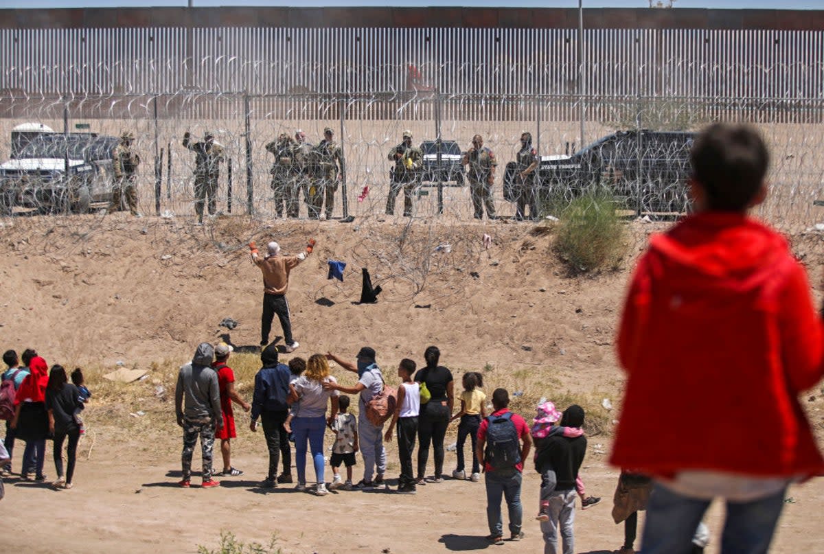 Migrants on the Mexican side of the US-Mexico border engage in a confrontation with Texas National Guard troops on May 13, 2024  (AFP via Getty Images)