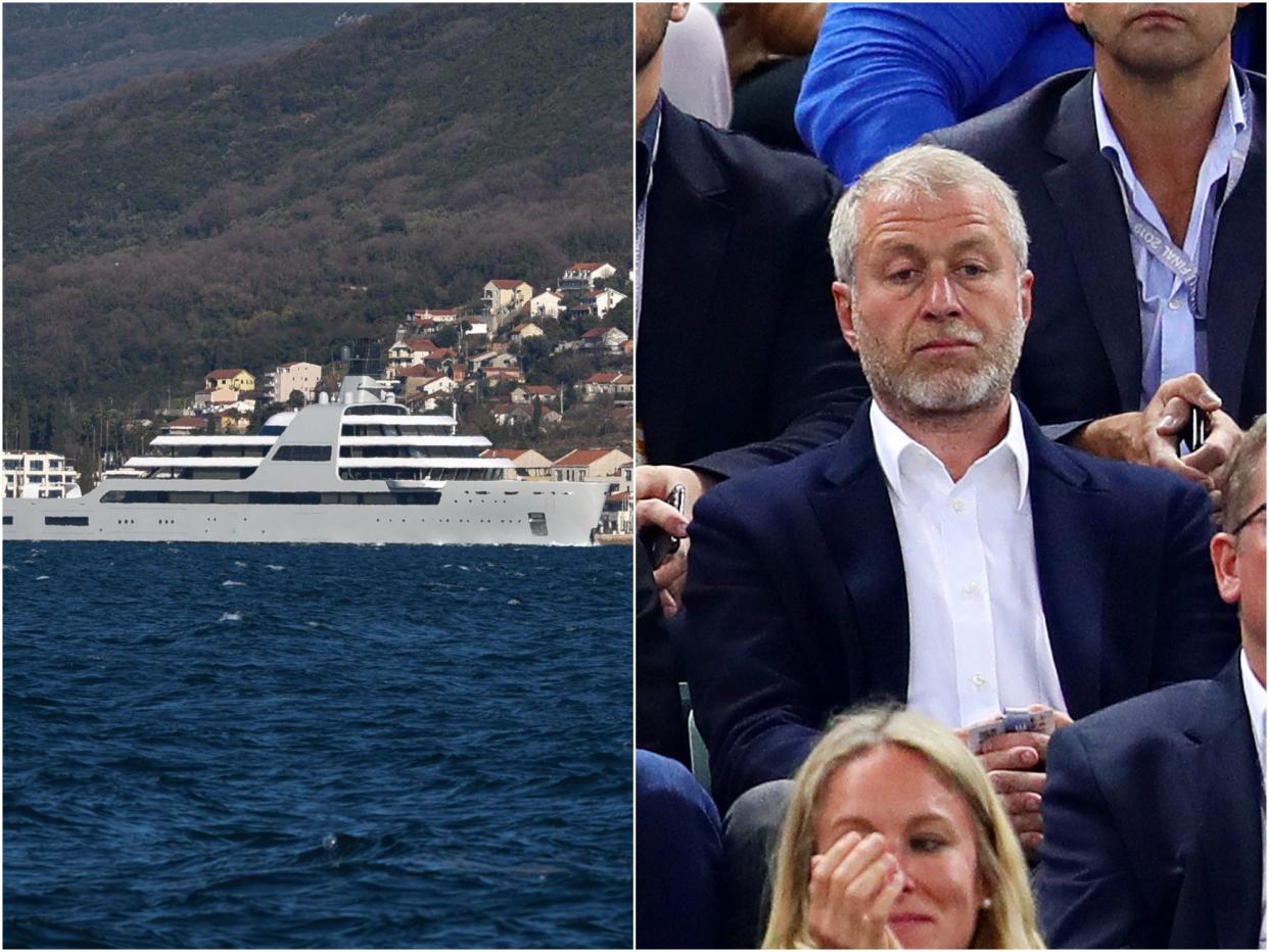 Roman Abramovich sat in a crowd next to a picture of his yacht, Solaris.