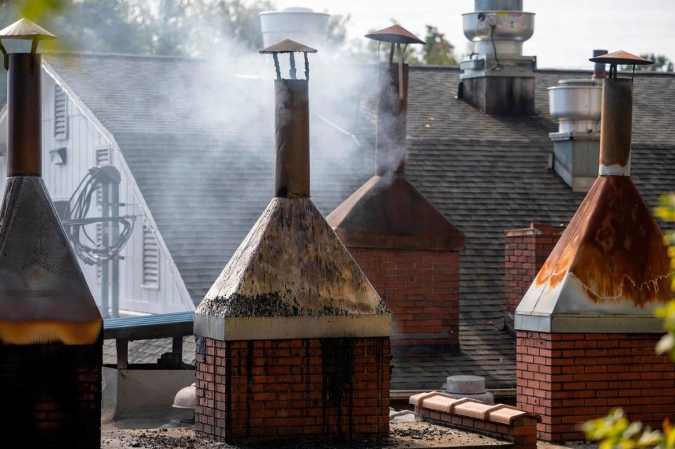 Smoke billows from a pit room chimney over Lexington Barbecue on Tuesday, October 10, 2023 in Lexington, N.C. The popular barbecue restaurant prepares their pork shoulders over wood coals.