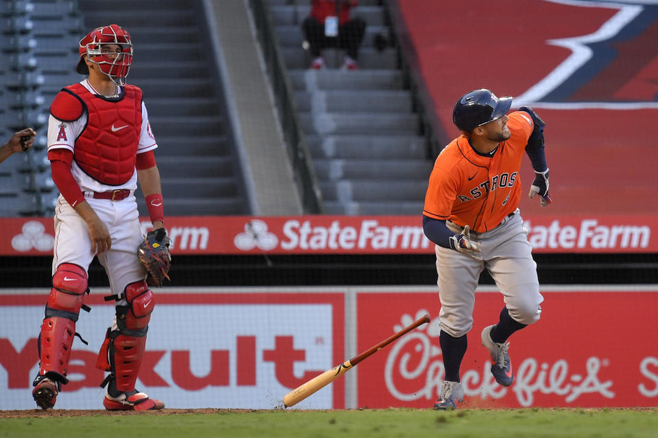 Houston Astros' George Springer runs to first after hitting a two-run home run, next to Los Angeles Angels catcher Max Stassi during the ninth inning of a baseball game Saturday, Aug. 1, 2020, in Anaheim, Calif. (AP Photo/Mark J. Terrill)