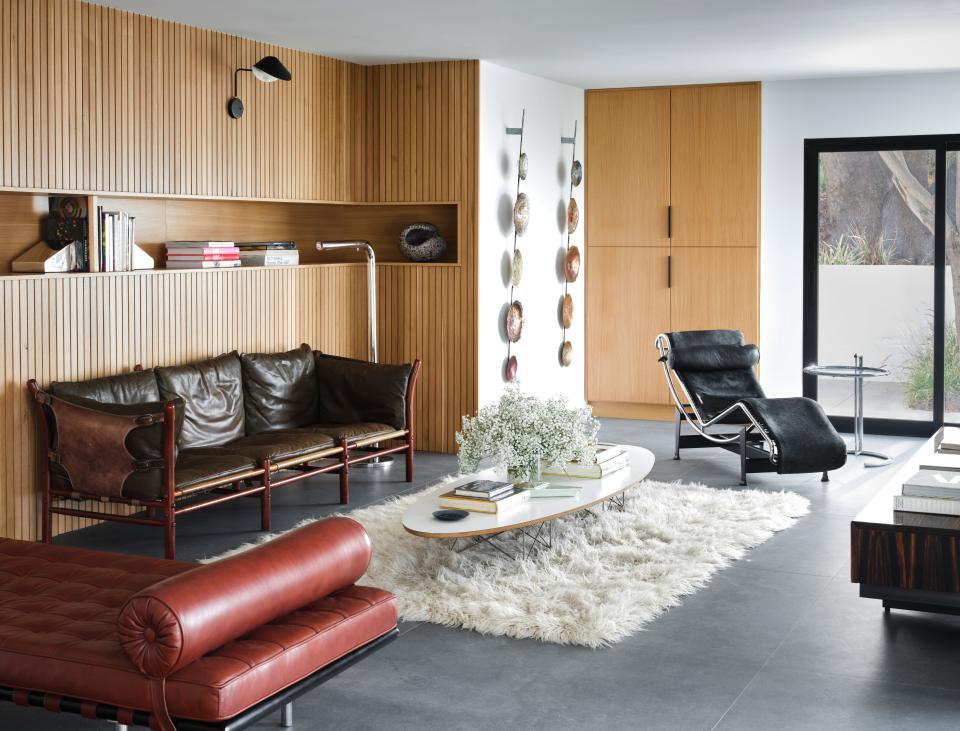 A secondary living room features a lounge chair from Le Corbusier and coffee table from Charles and Ray Eames; the brown sofa is a Mies Van Der Rohe Barcelona daybed.