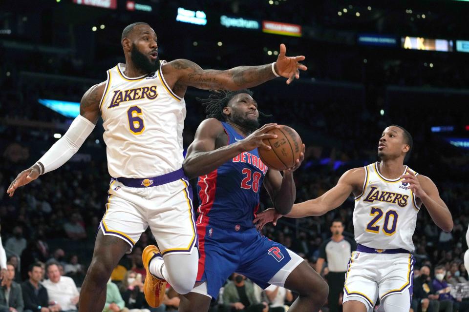 Pistons center Isaiah Stewart is defended by Lakers forward LeBron James, left, and guard Avery Bradley in the first half on Sunday, Nov. 28, 2021, in Los Angeles.