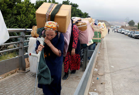 Moroccan women carry goods to be taken across the border from Spain's North African enclave of Melilla into Moroccan settlement of Beni Ansar, in Melilla, Spain July 18, 2017. Picture taken July 18, 2017. REUTERS/Youssef Boudlal