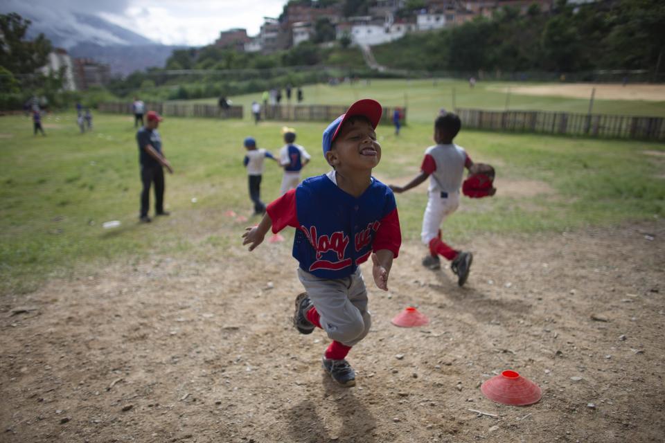 In this Aug. 12, 2019 photo, a young baseball player playfully rolls his tongue as he runs during drills at a practice at Las Brisas de Petare Sports Center, in Caracas, Venezuela. A junior team from Maracaibo, Venezuela is representing Latin America this week in the Little League Baseball World Series in South Williamsport, Pennsylvania. (AP Photo/Ariana Cubillos)