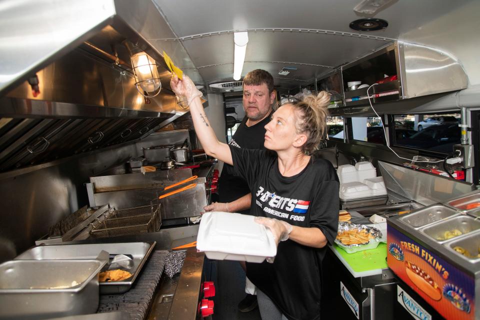 Sean DeSmet, owner of 3-D Eats and Tea, and Josie Burkett prepare lunch for hungry customers at Ascension Sacred Heart on Friday. DeSmet and other food truck vendors are joining forces for a Hunger Games fundraising throwdown event Oct. 15.