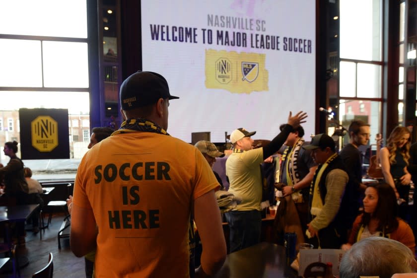 A Nashville SC fan looks for a seat before the start of the Major League Soccer expansion draft Tuesday, Nov. 19, 2019, in Nashville, Tenn. (AP Photo/Mark Zaleski)